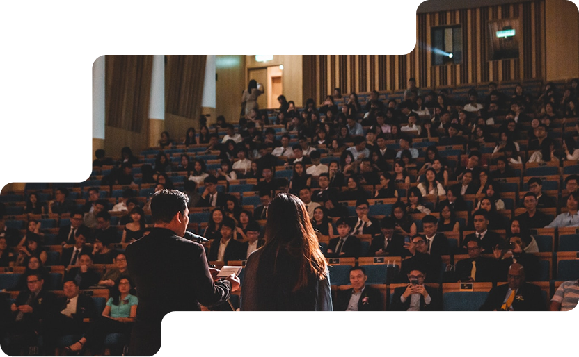Ascendra leaders addressing members in an auditorium gathering